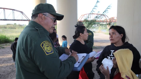 Un agente de la CBP con inmigrantes en la frontera.