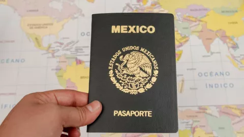 Una mano que sostiene un pasaporte mexicano.