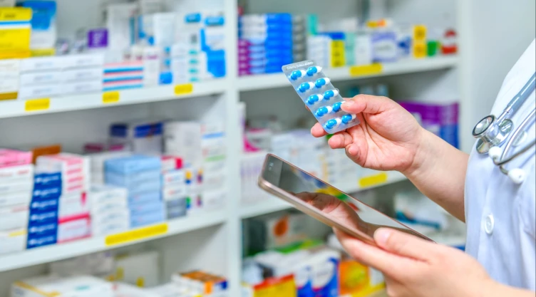 Postal de un farmacéutico que visualiza recetas en una farmacia