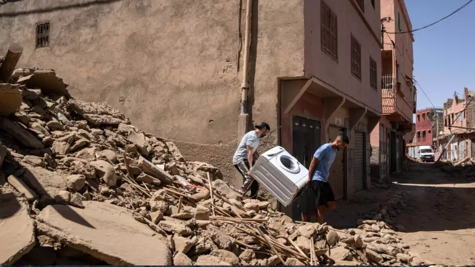 Dos personas recuperan una lavadora treas un sismo en Marruecos.