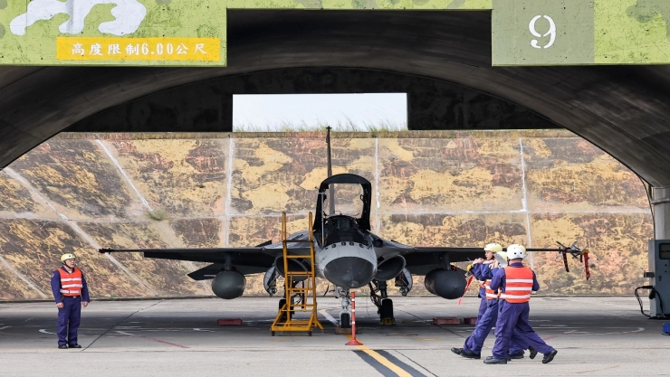 Fotografía que muestra un caza IDF en un hangar, con personal militar y vehículos de emergencia alrededor.