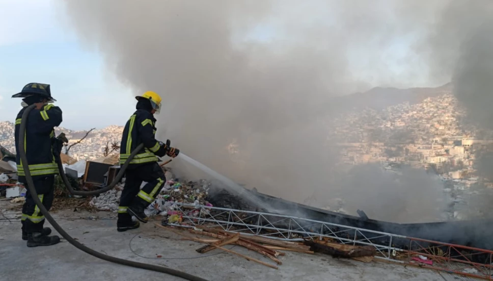 Bomberos apando el fuego tras la quema de basura en callles de Acapulco, Guerrero.