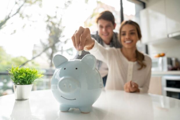 pareja depositando dinero en alcancia.jpg