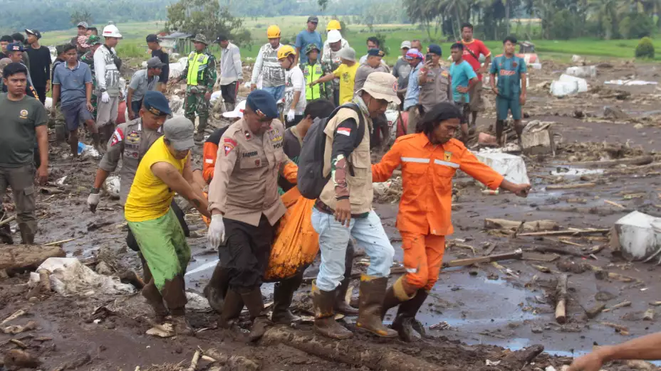 Rescatistas trasladan una víctima de inundaciones en Indonesia.