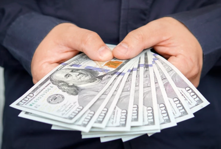 un hombre contando dólares con sus manos