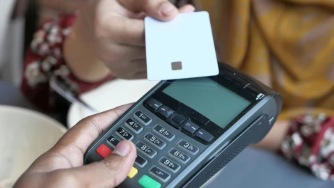 Una persona pagando con su tarjeta de crédito