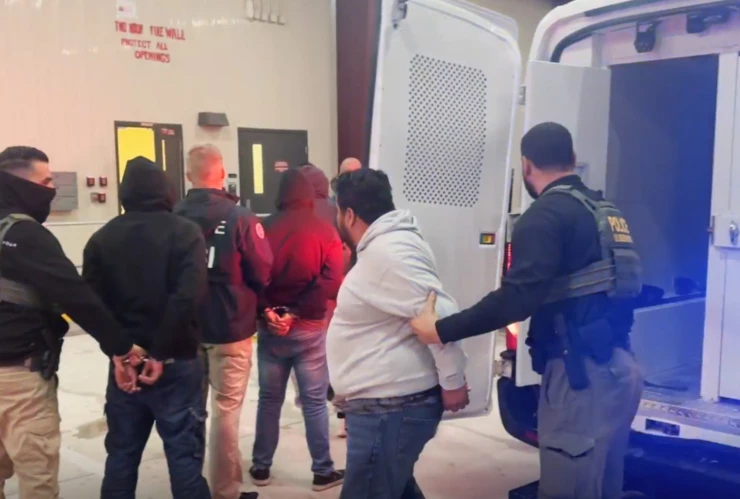 Agentes del ICE escoltan a los inmigrantes detenidos
