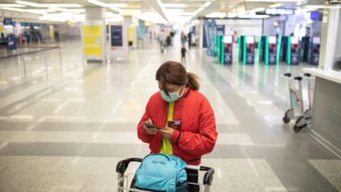 Una pasajera revisa su teléfono móvil cuando Serbia detiene todos los vuelos comerciales desde el aeropuerto Nikola Tesla de Belgrado para prevenir la propagación de la enfermedad por coronavirus (COVID-19).