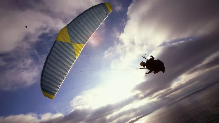 Migrante cruza la fronte con un parapente