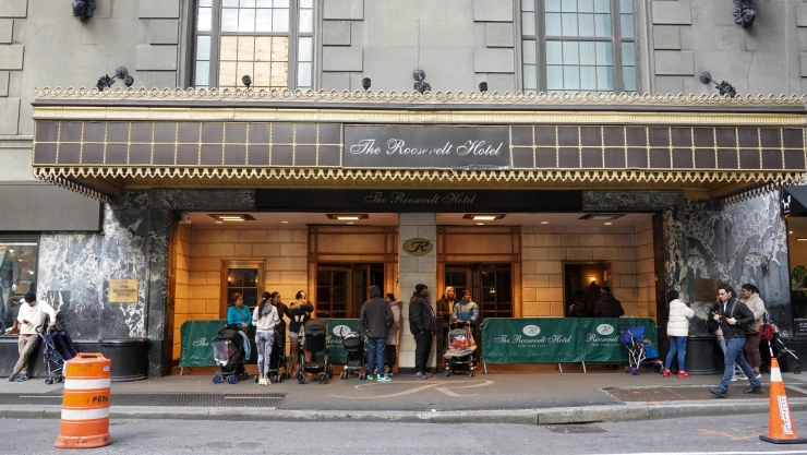 Inmigrantes en la puerta de un hotel de Nueva York