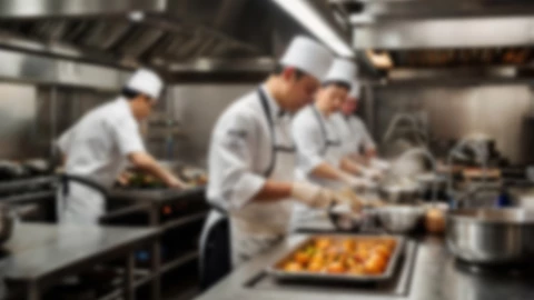 Los chef elaborando los platillos en la cocina, de ambo, delantal y sombrero blanco, en un restaurante de categoría