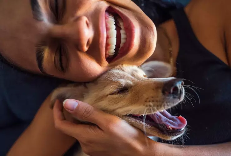 mujer aparentemente feliz a lado de su perro