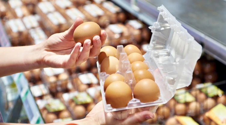 Una persona compra huevos en un supermercado.