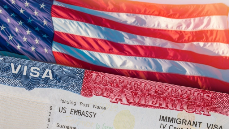 Una visa americana sobre una bandera de Estados Unidos.