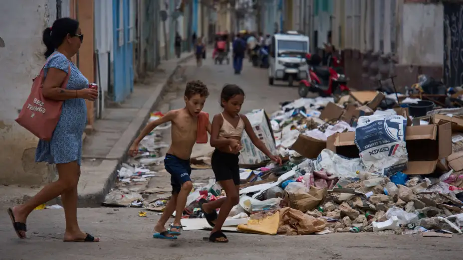 Niños pasan junto a un montón de basura en la Habana, Cuba.jpg