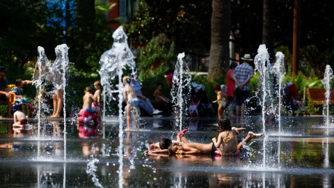 Children cool off in a fountain in Nice as a heat wave hits France