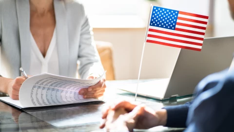 Una funcionaria firma un documento de solicitud de visa