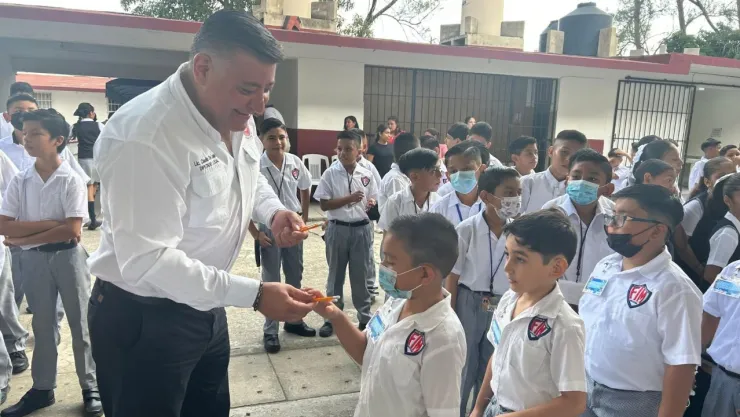 Claudio de Leija presume orgullo al regalar lápices a alumnos.
