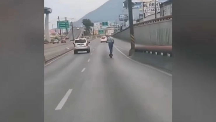 Hombre en “scooter” viaja por vialidades transitadas de Monterrey.