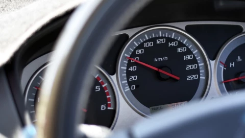 Un indicador de velocidad en el panel del coche.