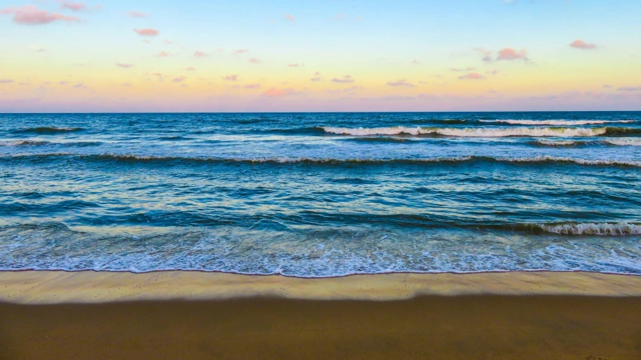 Atardecer en una playa con oleaje