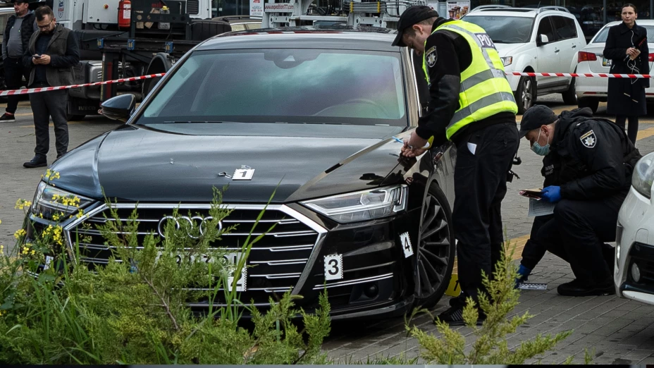 Policías recogen pruebas tras atentado contra auto del primer asistente del presidente de Ucrania.