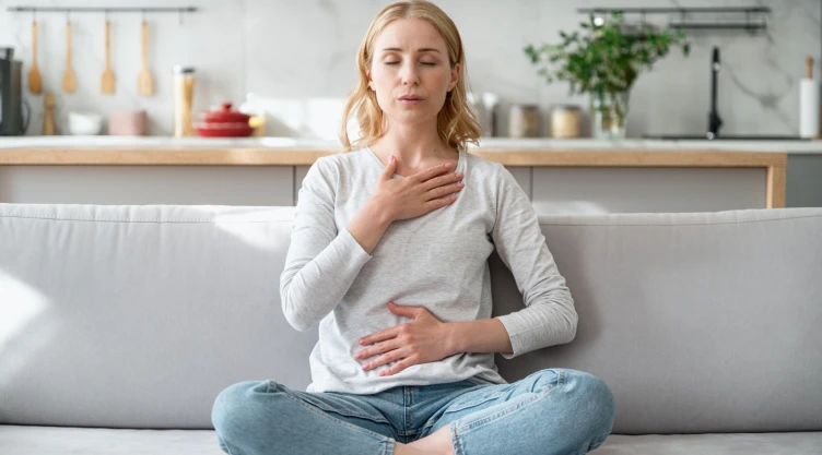 Una mujer trata de respirar ante un ataque de ansiedad.