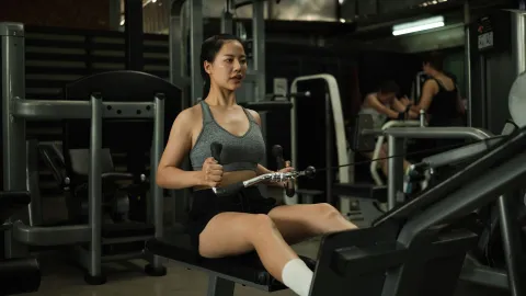 Mujer utilizando la máquina de remo en un gimnasio