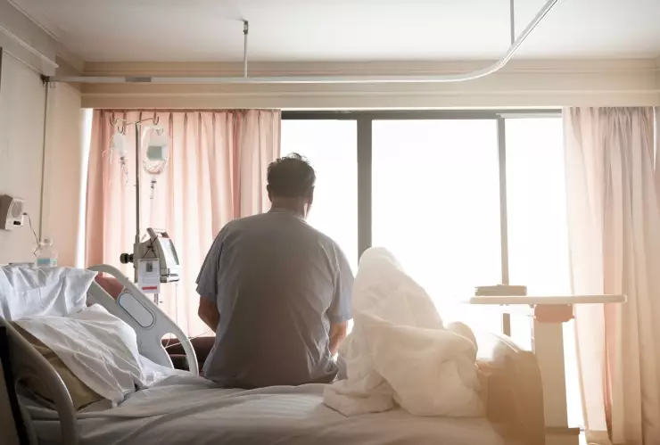 Un paciente sentado en una cama de hospital.