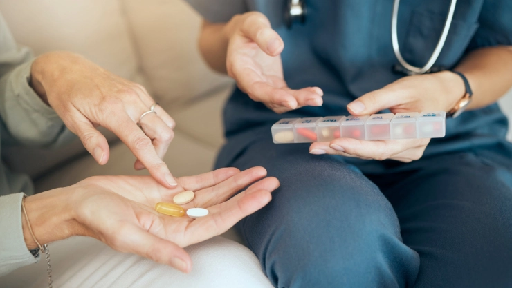 Una profesional de salud entrega medicación a una paciente.