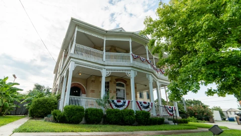 Una casa de dos plantas en un pueblo de Texas, con un parque verde de entrada prolijo y plantas en su alrededor