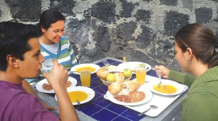 Tres estudiantes de la UNAM comiendo en las instalaciones de CU.