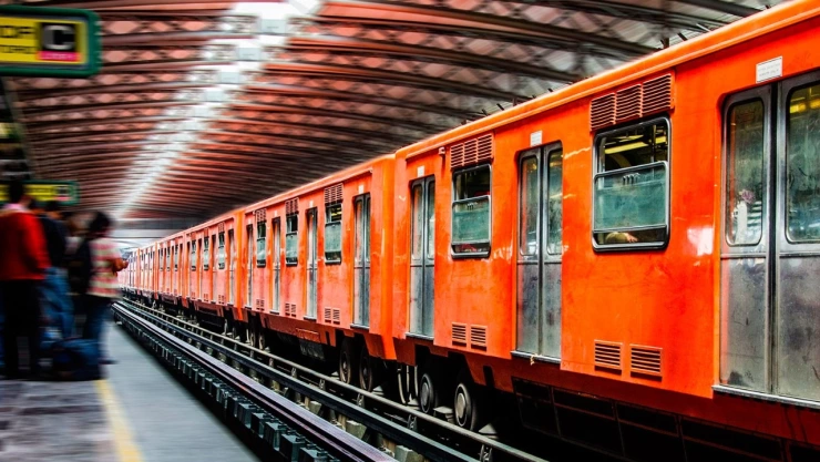 Tren del Metro CDMX y gente dentro de una estación.