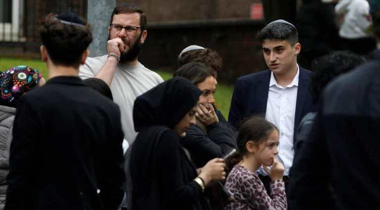 Testigos fuera de sinagoga en Manchester, tras ataque del 2 de octubre de 2025.