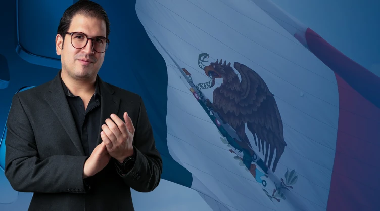 Juan Pablo Delgado con la bandera de México de fondo.