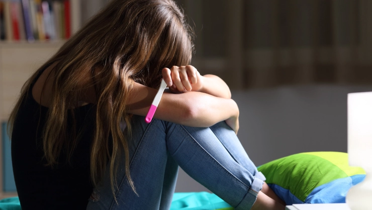 Sad pregnant teen after pregnancy test