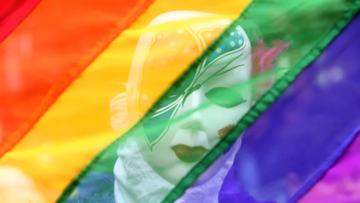 Un participante se para detrás de una bandera del arcoíris durante un desfile del orgullo gay que promueve los derechos de lesbianas, gays, bisexuales y transexuales, en Chennai