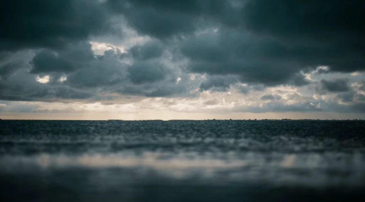 Mar con nubes grises reflejando una tormenta.
