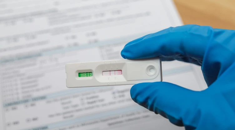 Una mano sostiene una prueba de coronavirus positiva