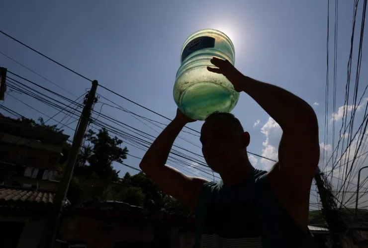Un hombre lleva un galón vacío para buscar agua después de quedarse sin ella en su casa en medio de una ola de calor extrema en Brasil.