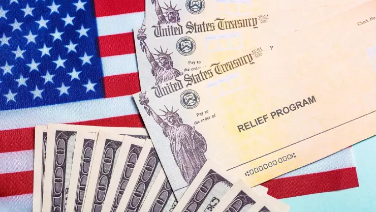 un concepto del programa que ayuda económicamente a las familias, dólares y la bandera de Estados Unidos.