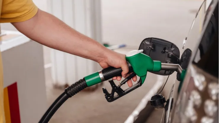 Una persona carga gasolina a su vehículo.