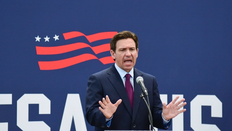 Ron DeSantis hablando en una conferencia con las manos abiertas