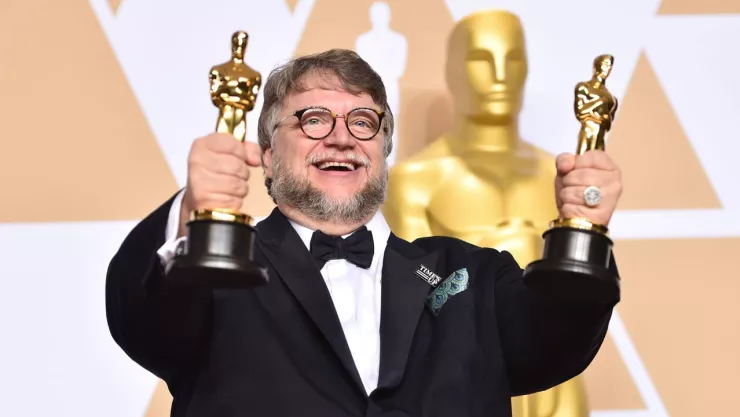 Guillermo del Toro con dos estatuillas de los Premios Oscar