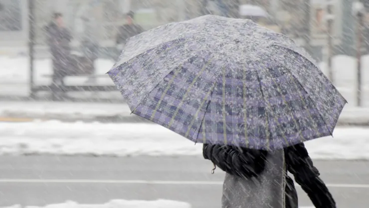 Persona bajo la nieve con un paraguas
