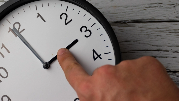 Mano ajusta manecillas de un reloj