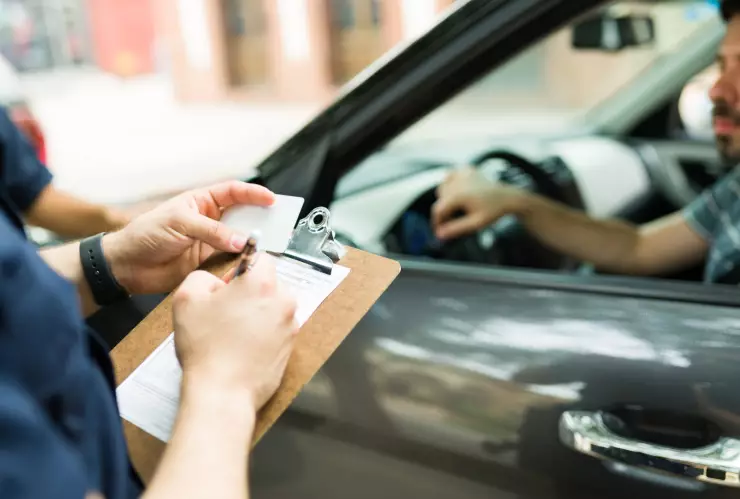 Un agente rellena una notificación al frenar a un conductor
