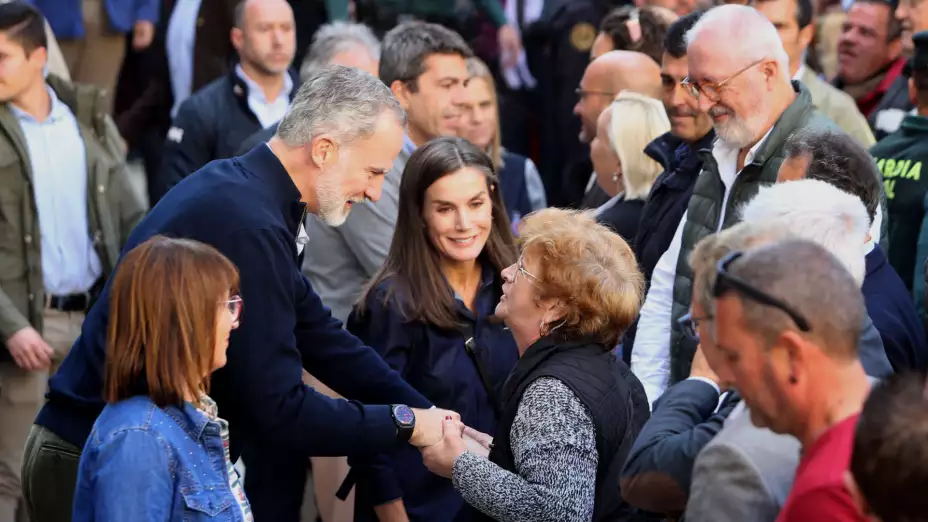 El rey Felipe VI de España habla con una mujer junto a la reina Letizia en Chiva, Valencia.