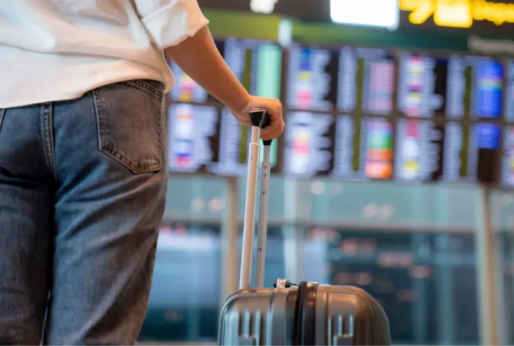 mujer con maleta en mano en un aeropuerto