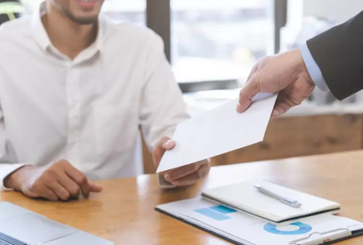 Una persona recibe un sobre con un cheque.